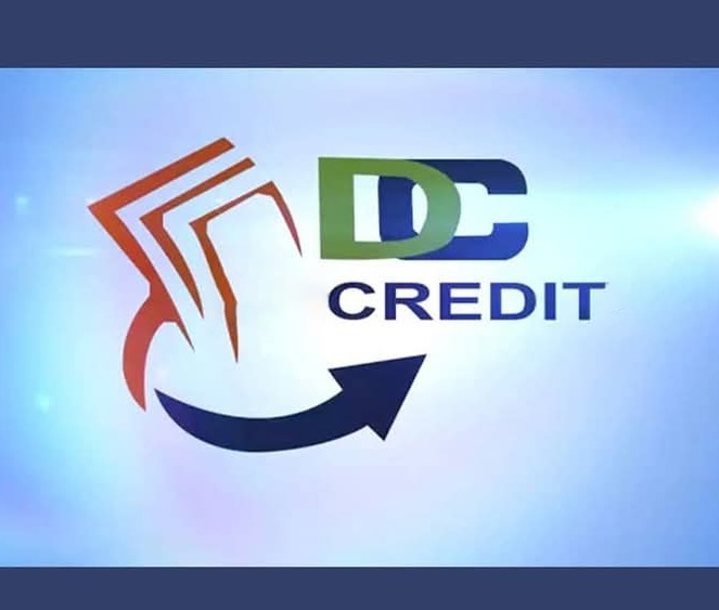 Laptop displaying financial chart alongside documents and credit cards on desk.